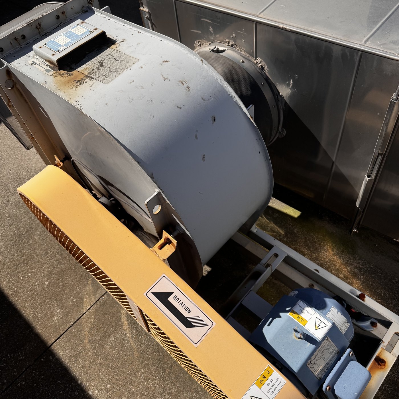 exhaust fan before memolub em 자동급유기 설치 전 옥상 배기팬의 회색 케이싱과 노란 벨트 보호커버, 파란 모터