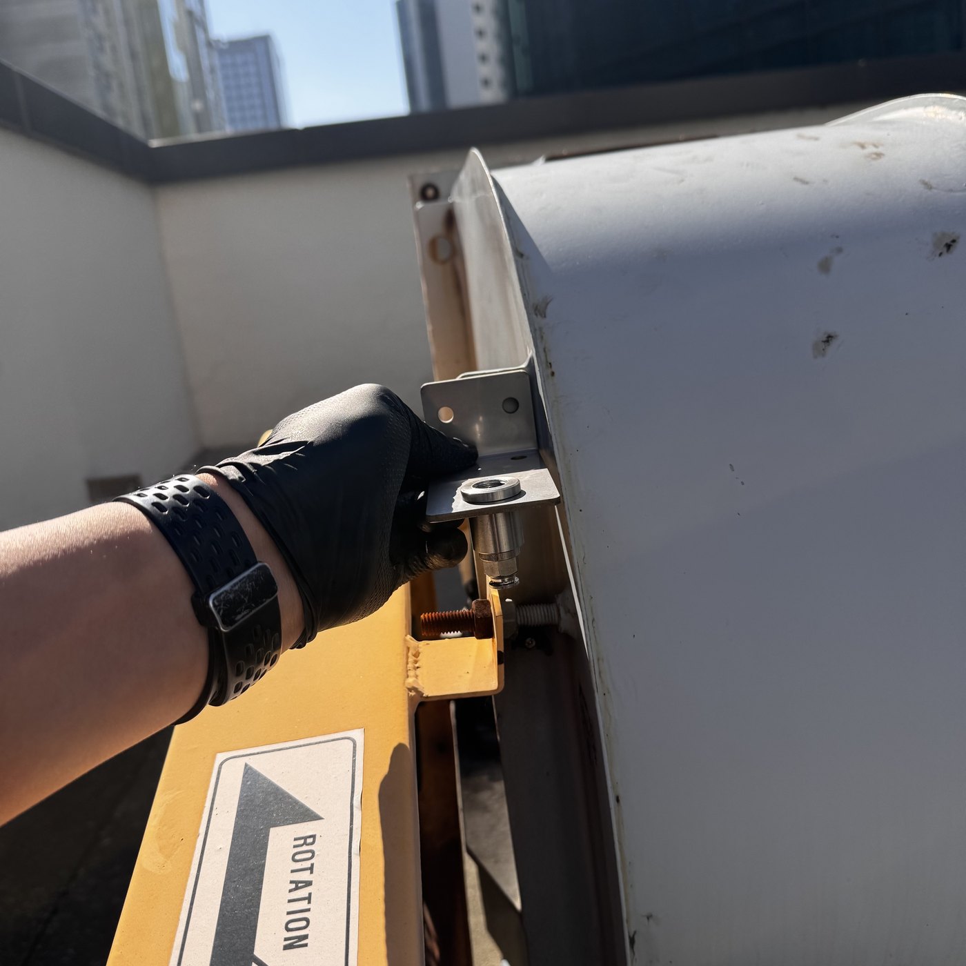 exhaust fan memolub em bracket 작업자가 배기팬 측면에 메모루브 EM 고정용 금속 브래킷을 맞추는 설치 과정